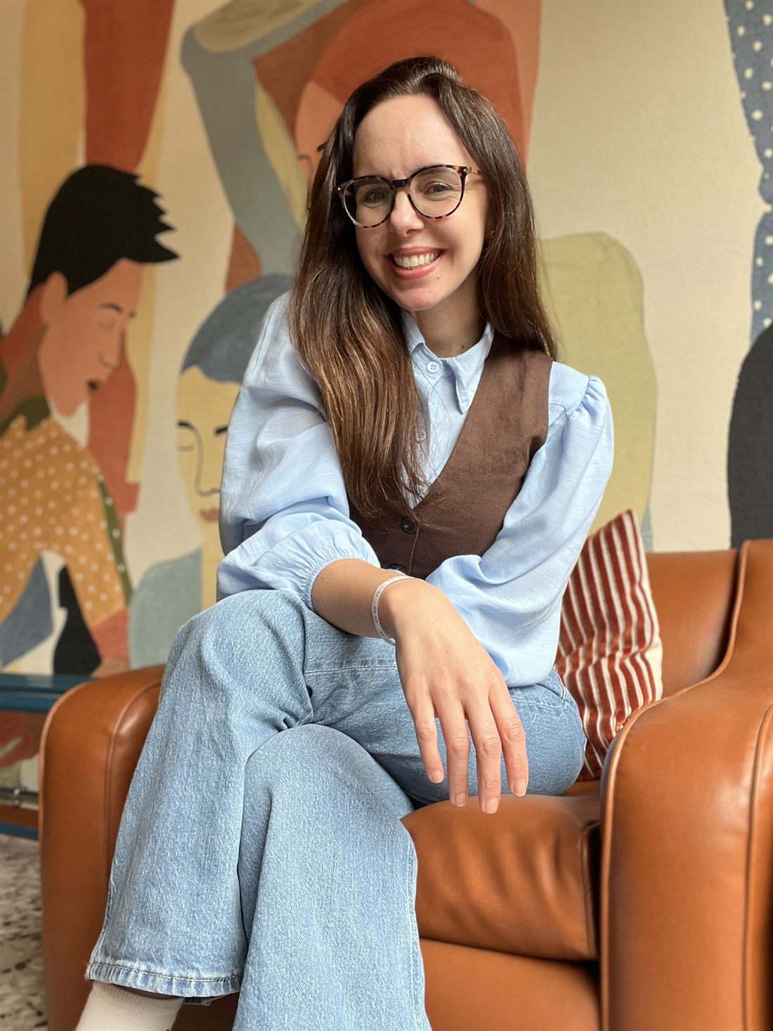 Joice Belisario seduta davanti a un murale colorato