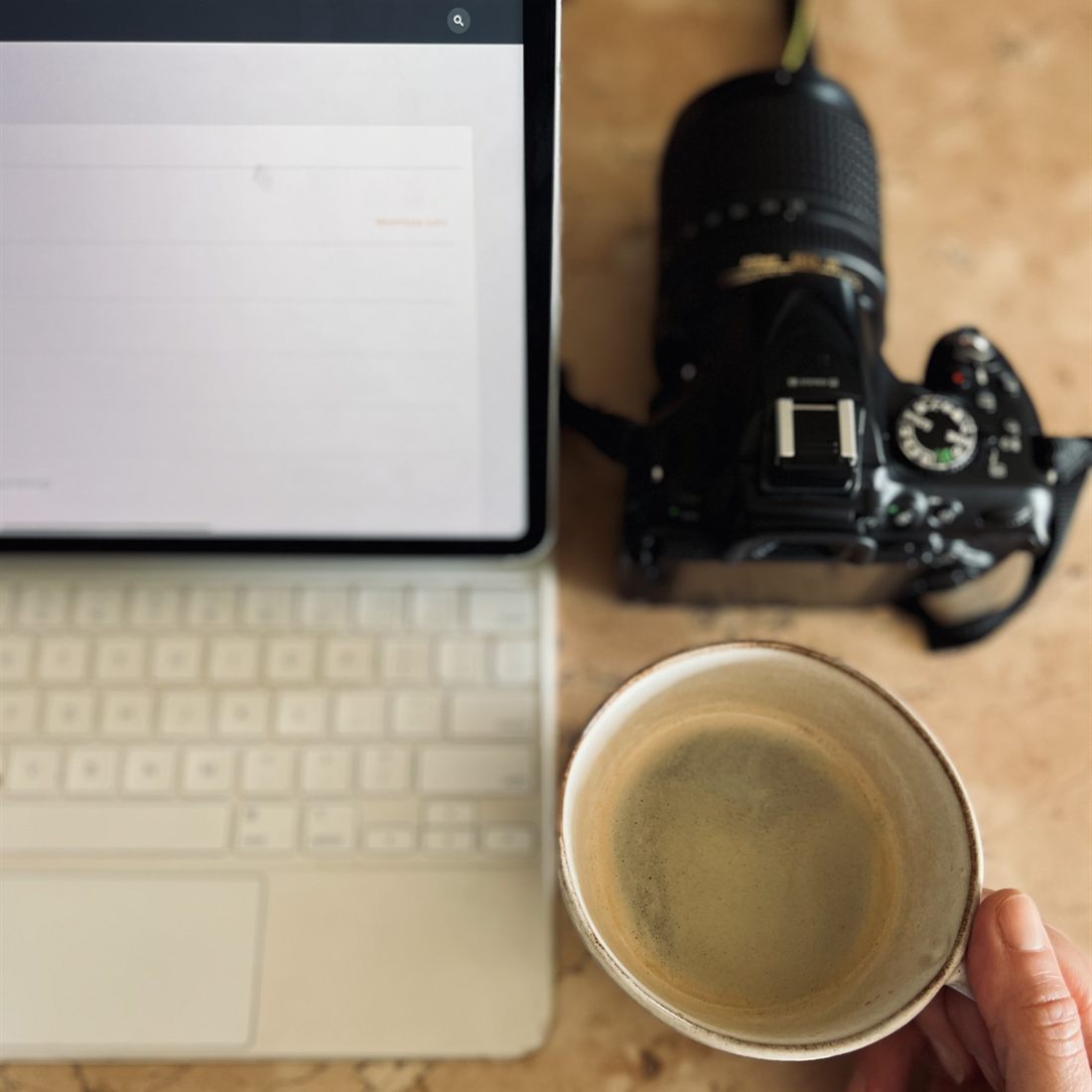 Tablet, macchina fotografica e caffè sul tavolo